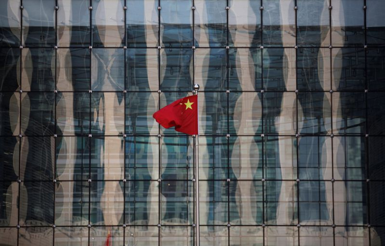 Un drapeau national chinois flotte devant le siège d'une banque commerciale