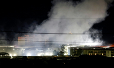 De la fumée au-dessus de bâtiments après une explosion au complexe de KK Park, dans l'est de la Birmanie, vue depuis le district de Mae Sot, dans la province de Tak en Thaïlande, le 24 octobre 2025 ( THAI NEWS PIX / Sarot Meksophawannakul )