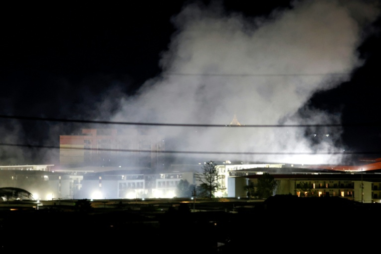De la fumée au-dessus de bâtiments après une explosion au complexe de KK Park, dans l'est de la Birmanie, vue depuis le district de Mae Sot, dans la province de Tak en Thaïlande, le 24 octobre 2025 ( THAI NEWS PIX / Sarot Meksophawannakul )