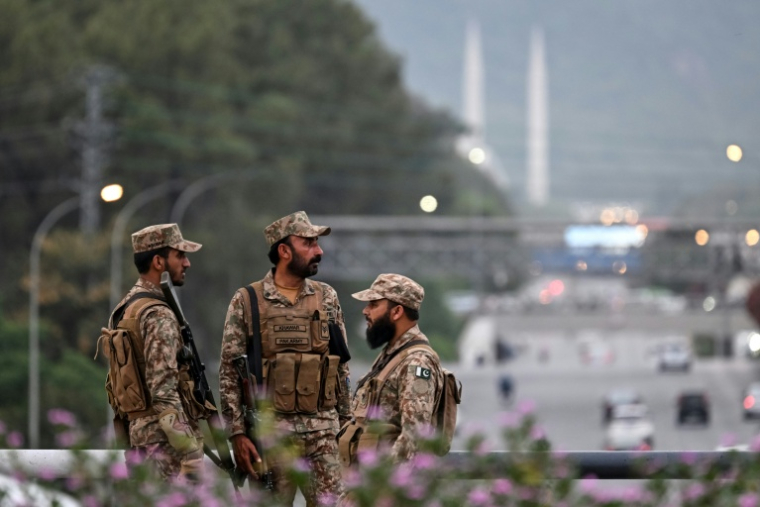 Des soldats montent la garde dans une rue menant à la zone rouge en prévision des pourparlers de paix américano-iraniens à Islamabad, le 24 avril 2026 au Pakistan ( AFP / Farooq NAEEM )