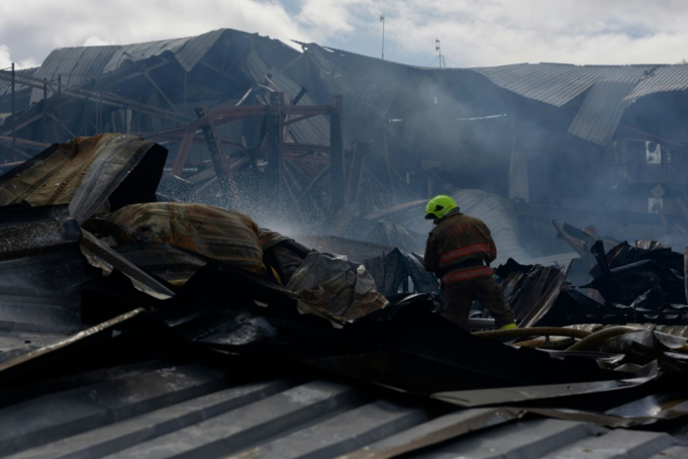 Des pompiers éteignent un incendie dans un entrepôt détruit par une frappe russe dans la région de Kiev, en Ukraine, le 22 septembre 2026. ( AFP / Tetiana DZHAFAROVA )