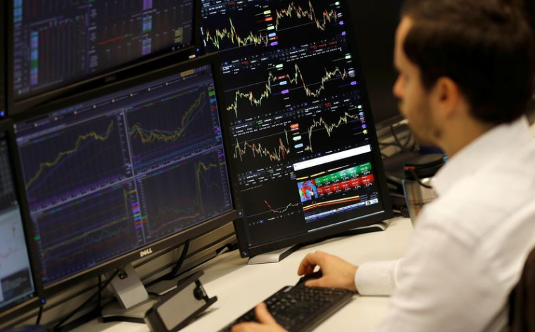 Un trader financier travaille à son bureau chez CMC Markets dans la City de Londres