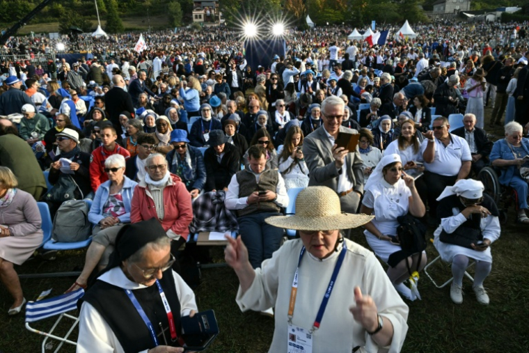 Des fidèles attendent l'arrivée du pape Léon XIV, le 27 septembre 2026 sur la prairie du sanctuaire à Lourdes, dans le sud-ouest de la France  ( AFP / Lionel BONAVENTURE )