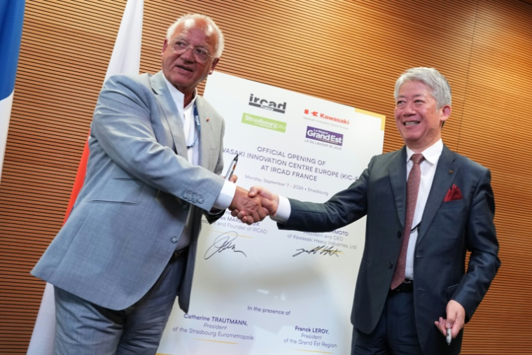 Jacques Marescaux (gauche), le président et fondateur de l'Institut de recherche contre les cancers de l'appareil digestif (Ircad), et Yasuhiko Hashimoto, le patron de Kawasaki Heavy Industries, se serrent la main lors d'une conférence de presse à Strasbourg, le 7 septembre 2026 ( AFP / Sébastien BOZON )