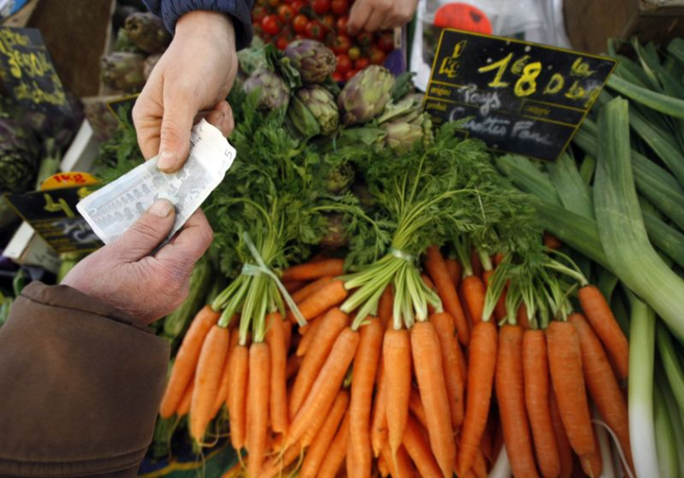 Un client achète des légumes sur un marché à Nice