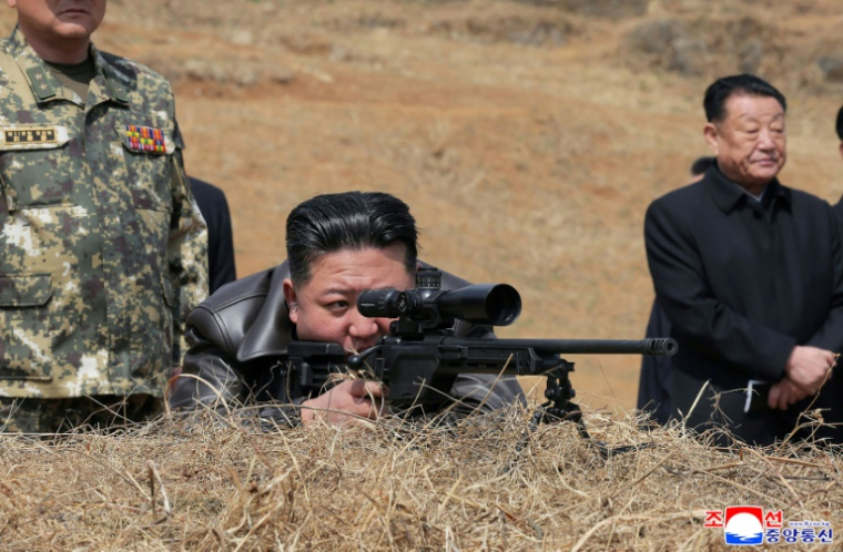Le dirigeant nord-coréen Kim Jong Un essaie un fusil de précision lors d'une visite dans un camp des forces spéciales, le 4 avril 2025 ( KCNA VIA KNS / STR )