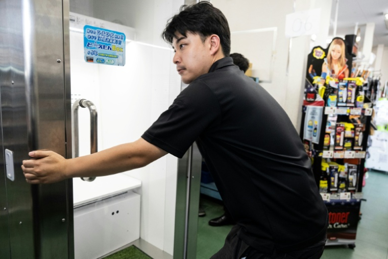 Un employé de Konoe déplace un "réfrigérateur humain", dans l'entrepôt de son entreprise, situé à Higashiosaka, dans la préfecture d'Osaka, le 21 août 2026 ( AFP / ANDREW CABALLERO-REYNOLDS )