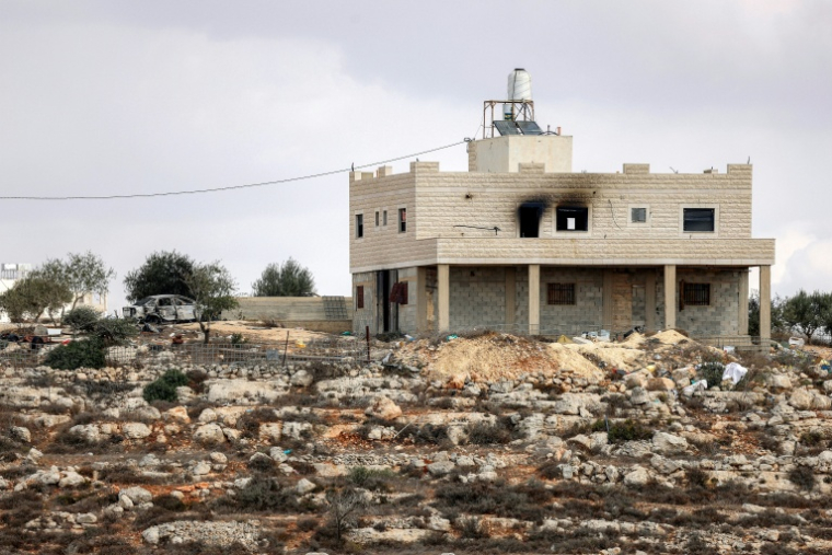 Des colons et des agents de sécurité israéliens à proximité de la maison d'une famille palestinienne, dans le village de Jalud, en Cisjordanie, le 29 septembre 2026 ( AFP / Zain JAAFAR )