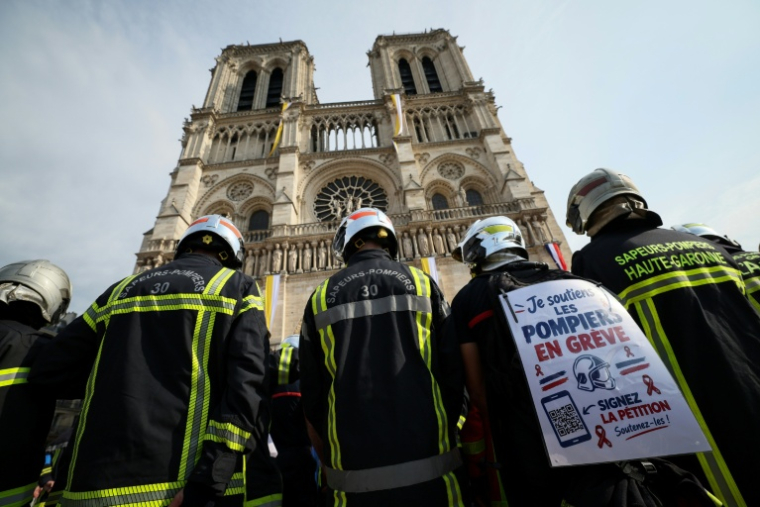 Manifestation de pompiers pour réclamer des hausses de salaires et des moyens budgétaires accrus, le 28 septembre 2026 devant la cathédrale Notre-Dame de Paris ( AFP / Xavier GALIANA )