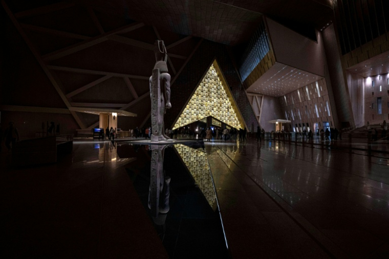 Des visiteurs déambulent près de la statue colossale du roi Ramsès II à l'entrée du Grand musée égyptien (GEM)  au Caire le 7 février 2025, avant l'ouverture officielle ( AFP / Khaled DESOUKI )