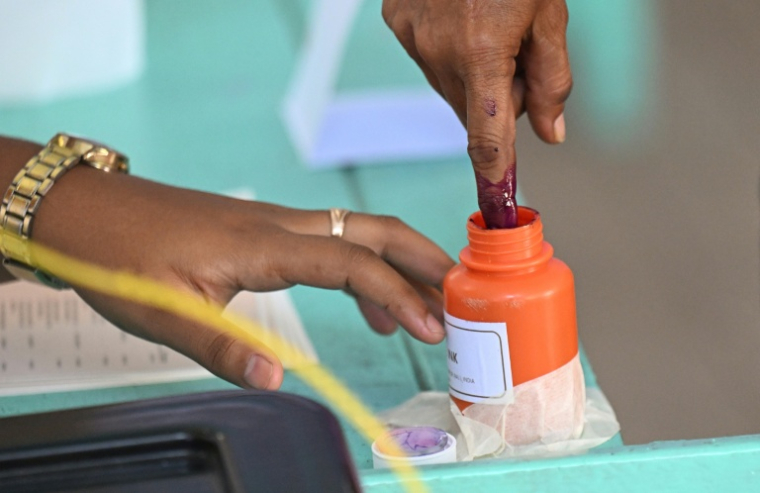 Un homme trempe son index dans de l'encre après avoir voté lors de l'élection présidentielle au Guyana, à Georgetown, le 1er septembre 2025 ( AFP / Joaquin Sarmiento )
