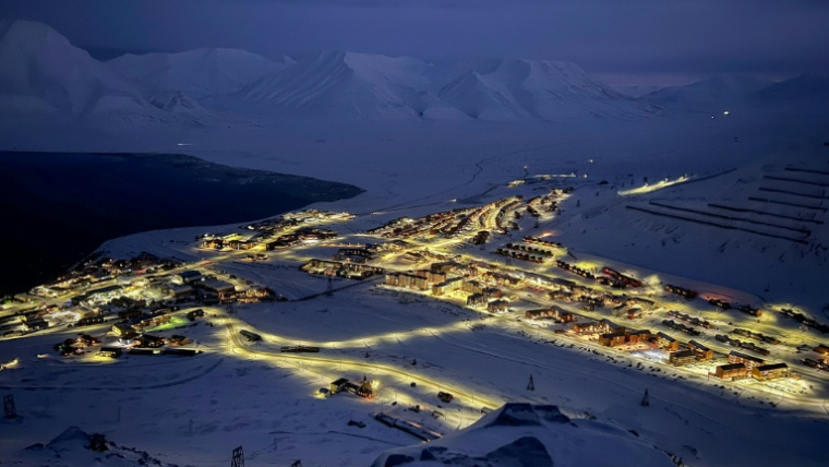 Des bâtiments illuminés à Longyearbyen, dans l'archipel norvégien du Svalbard, quelques jours avant le retour du soleil, le 8 février 2026 ( AFP / Oriane Laromiguière )
