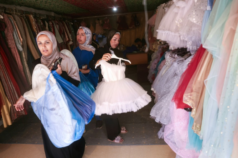 Des femmes palestiniennes dans une boutique de robes pour les grandes occasions à Khan Younès dans le sud de la bande de Gaza le 13 juin 2026. ( AFP / BASHAR TALEB )