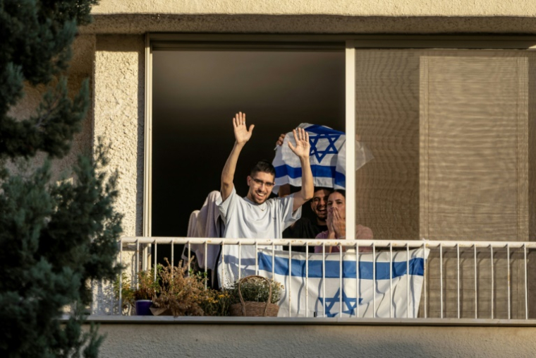 Eviatar David, libéré par le Hamas après avoir été retenu en otage pendant plus de deux ans, salue la foule depuis son domicile à Kfar Saba, dans le centre d'Israël, le 26 octobre 2025  ( AFP / FADEL SENNA )