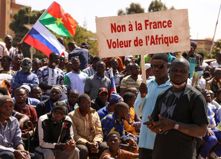 Une personne à Ouagadougou tient une pancarte alors que les gens protestent contre la présence de la France au Burkina Faso