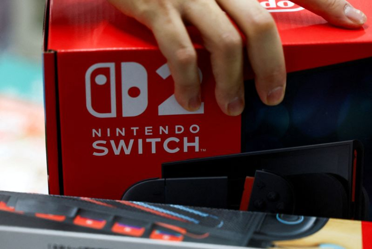 Une personne tient une boîte de console de jeu Nintendo Switch 2