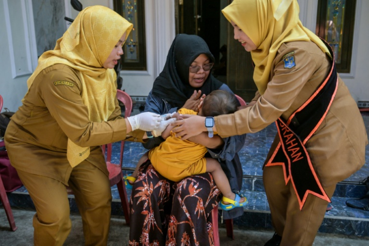 Une infirmière vaccine un enfant contre la rougeole lors d'une campagne de vaccination à Surabaya, en Indonésie, le 15 septembre 2025  ( AFP / Juni KRISWANTO )