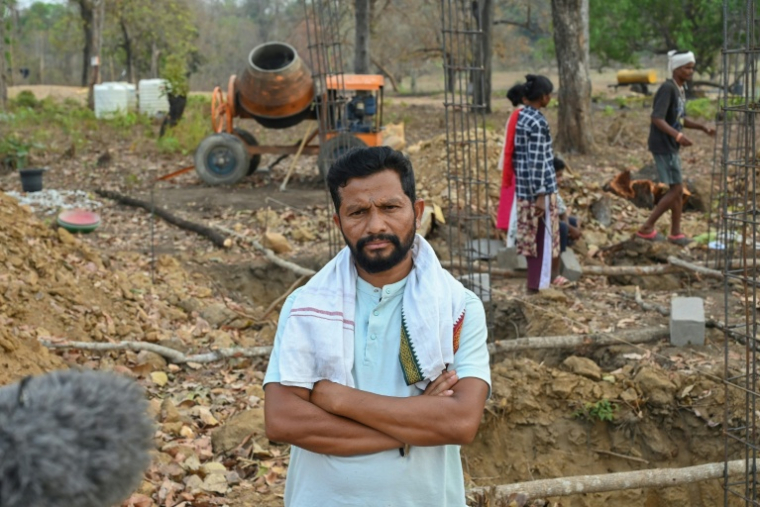 Umesh Sundam, dont le frère a été tué par les forces de sécurité après avoir été, à tort, qualifié d'insurgé, pose sur le site d'un grenier gouvernemental en construction à Dantewada, dans l'Etat de Chhattisgarh, le 31 mars 2026 en Inde ( AFP / Shammi MEHRA )