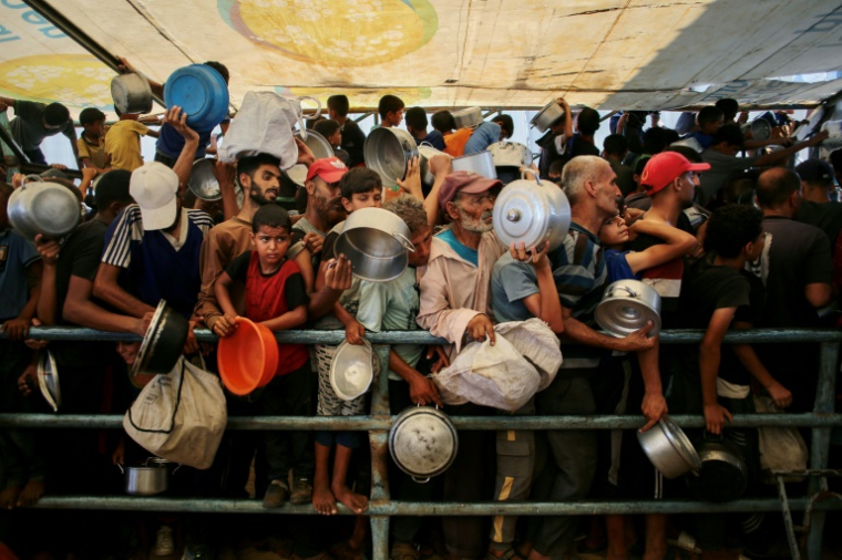 Des Palestiniens attendent de recevoir un repas chaud distribué par une cuisine caritative à Khan Younès, dans le sud de la bande de Gaza, le 22 juillet 2025 ( AFP / - )