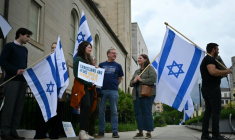 Des personnes brandissent des pancartes et des drapeaux israéliens en signe de soutien devant le Musée juif de Washington, aux Etats-Unis, le 22 mai 2025 ( AFP / Drew ANGERER )