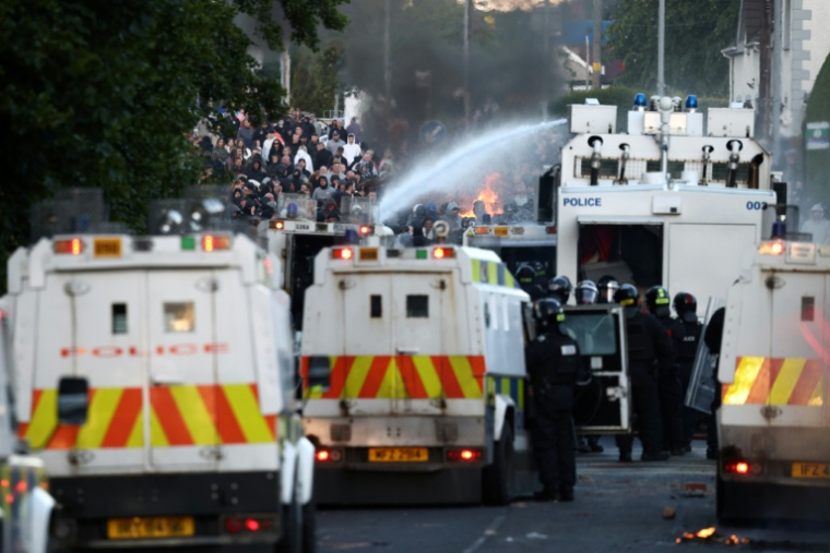 PLa police utilise des canons à eau pour bloquer la route aux manifestants à Glegormley, au nord de Belfast, le 10 juin 2026 en Irlande du Nord ( AFP / Henry NICHOLLS )