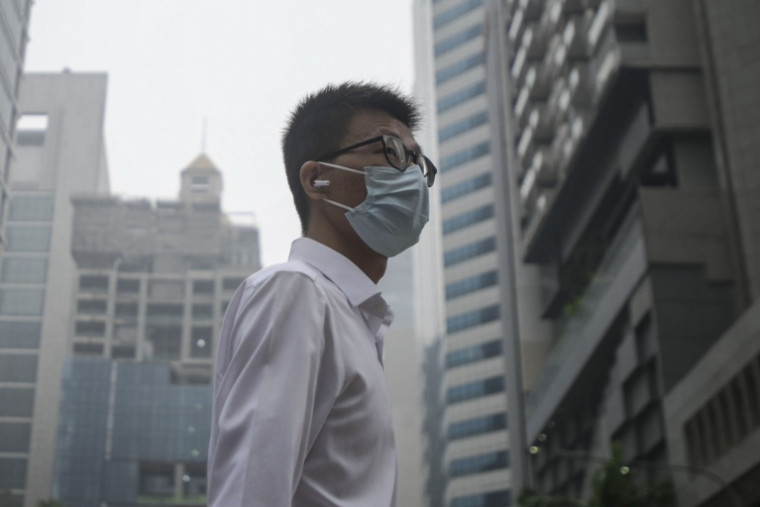 Un homme porte un masque pour se protéger de la pollution due aux incendies dans la région, à Singapour, le 15 octobre 2026 ( AFP / FELINE LIM )