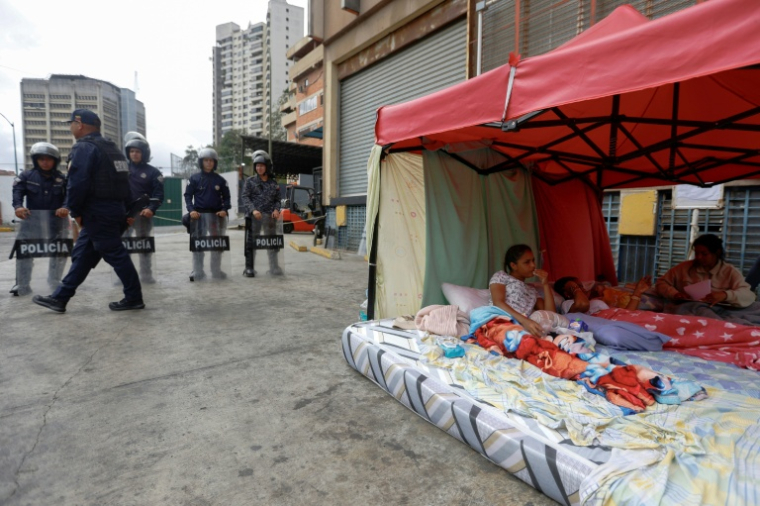 Des proches de prisonniers politiques, qui ont mené une grève de la faim de près d’une semaine et qui s’est achevée la veille, restent devant la prison de la Zone 7 de la Police nationale bolivarienne à Caracas, le 20 février 2026 ( AFP / Pedro MATTEY )