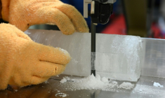 Le professeur Yoshinori Iizuka coupe une tranche d'un échantillon de carotte de glace, à l'Institut des sciences cryogéniques de l'université d'Hokkaido, à Sapporo, au Japon, le 9 décembre 2025 ( AFP / GREG BAKER )