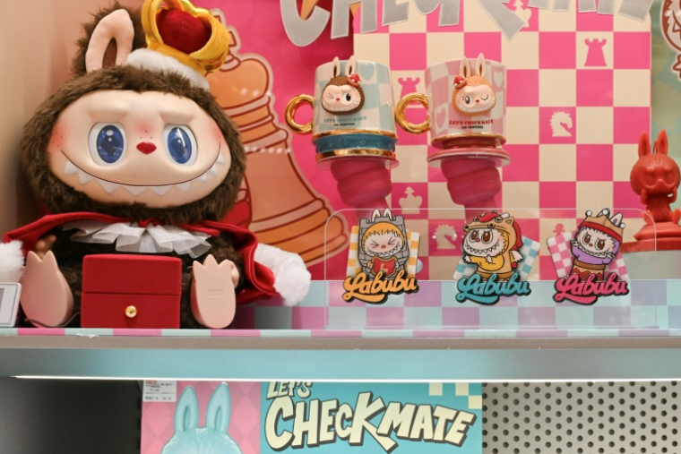 Une poupée et des stickers Labubu exposés  dans une boutique Pop Mart à Pékin, le 12 juin 2025 ( AFP / Adek BERRY )