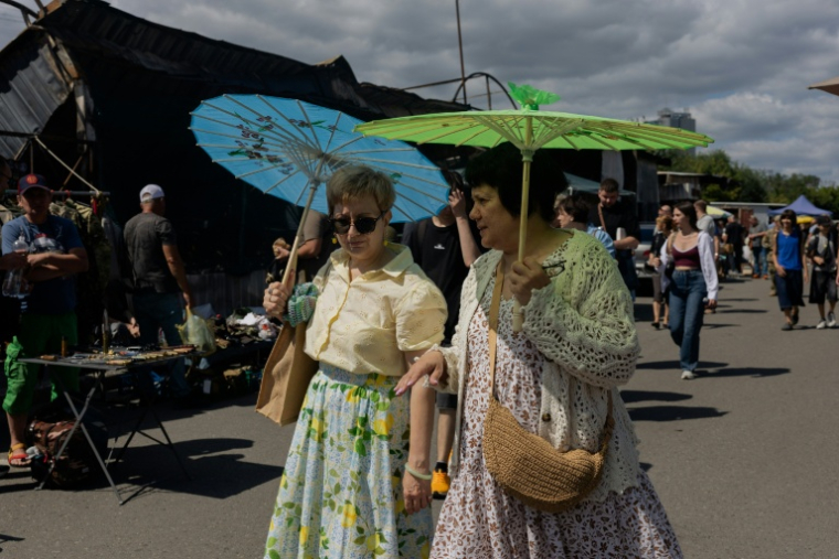 Des visiteuses au marché aux puces de Potchaïna endommagé par une frappe russe, le 9 août 2026 à Kiev, en Ukraine ( AFP / Tetiana DZHAFAROVA )