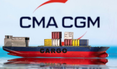 Un modèle de bateau cargo est photographié devant le logo de CMA CGM.