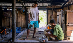 Le noble Umbu Ana Rara (g) regarde son esclave (d) Kanisius Kanyali Hambarita préparer des boissons au village de Tanggedu, dans l'est de l'île de Sumba, le 23 juin 2026 en Indonésie ( AFP / BAY ISMOYO )