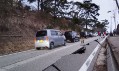 Des gens marchent le long d’une route endommagée par un tremblement de terre, à Wajima