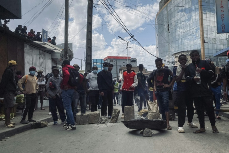 Des manifestants se tiennent près d'une barricade de fortune le 3 octobre 2025 à Antananarivo ( AFP / RIJASOLO )