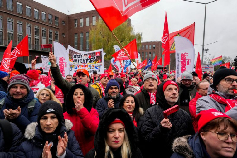 Des employés protestent lors d'une grève d'avertissement organisée par le syndicat IG Metall, devant le siège de Volkswagen à Wolfsburg