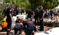 Des pompiers portent secours à un passant blessé après la chute d'un palmier sur la Croisette pendant le 78e Festival de Cannes, le 17 mai 2025 dans le sud de la France ( AFP / Miguel MEDINA )