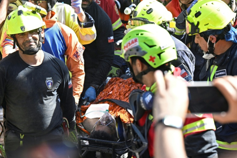 Une équipe internationale de secours transporte un rescapé sur une civière à Catia La Mar, dans l'Etat de La Guaira, le 2 juillet 2026, huit jours après du double séisme ayant frappé le Venezuela  ( AFP / Federico PARRA )