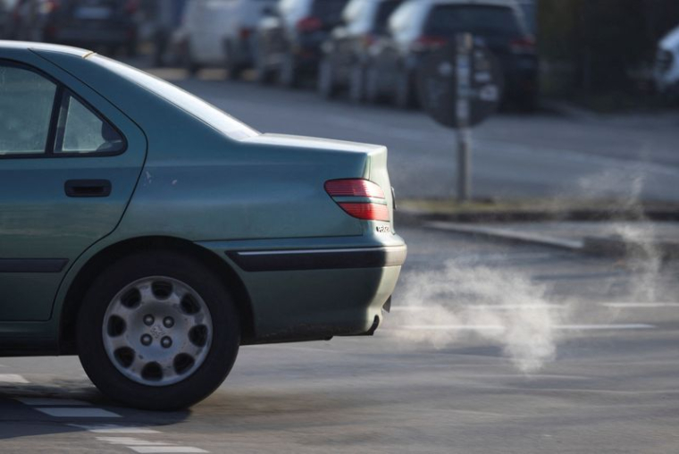 Un panache de gaz d'échappement blanc est expulsé du pot d'échappement d'un véhicule, à Berlin