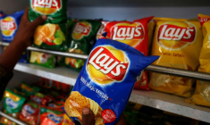 Un client choisit des paquets de chips Lay's dans un magasin