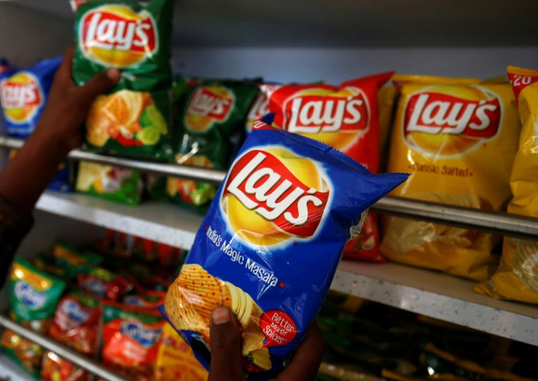 Un client choisit des paquets de chips Lay's dans un magasin