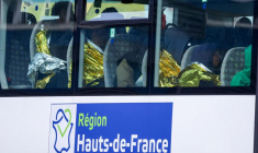 Des migrants sont assis dans un bus au port de Calais, après la mort de trois migrants, dont un enfant, qui tentaient de traverser la Manche de la France vers la Grande-Bretagne