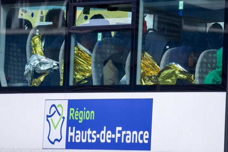 Des migrants sont assis dans un bus au port de Calais, après la mort de trois migrants, dont un enfant, qui tentaient de traverser la Manche de la France vers la Grande-Bretagne
