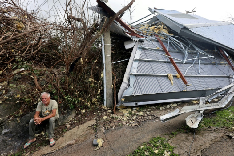 Un habitant est assis près d'une maison qui s'est effondrée sous les coups de boutoir du cyclone Garance à Saint-Benoît, sur l'île de La Réunion, le 1er mars 2025 ( AFP / Richard BOUHET )