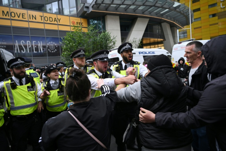 La police repousse des manifestants devant l'hôtel Britannia hébergeant des demandeurs d'asile à Canary Wharf, le 3 août 2025 à Londres ( AFP / JUSTIN TALLIS )