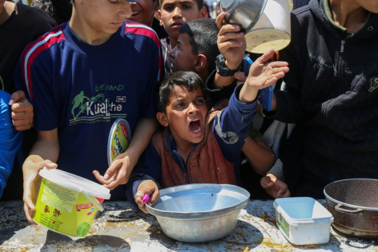 Distribution de nourriture dans le camp de réfugiés de Nousseirat, dans le centre de la bande de Gaza, le 5 mai 2025 ( AFP / Eyad BABA )