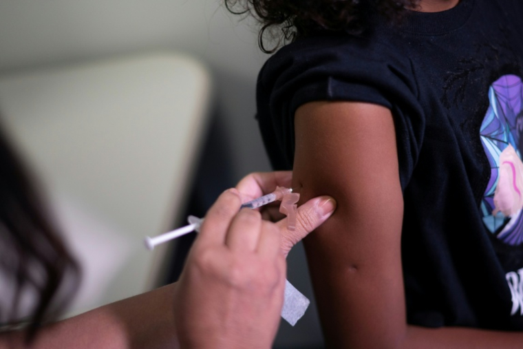 Une soignante vaccine une enfant contre la dengue dans un centre de santé de Belo Horizonte, dans l'État du Minas Gerais, le 2 mars 2024 au Brésil ( AFP / Douglas MAGNO )