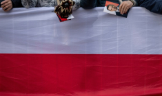 Une femme tient un tract de campagne du maire de Varsovie et candidat à la présidence, Rafal Trzaskowski, alors qu'elle et d'autres partisans de M. Trzaskowski se rassemblent sur le marché principal de Skierniewice, en Pologne, le 16 mai 2025 ( AFP / Wojtek RADWANSKI )