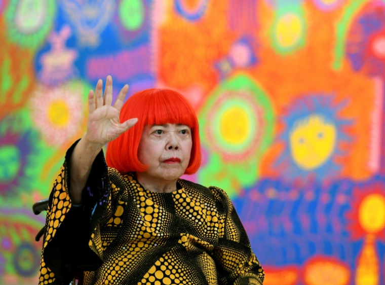 L'artiste japonaise Yayoi Kusama salue lors d’une séance photo pendant la préouverture presse de son exposition intitulée "Mon âme éternelle" au National Art Center de Tokyo, le 21 février 2017 ( AFP / TOSHIFUMI KITAMURA )