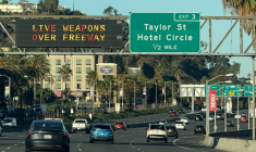 Un panneau (g) d'autoroute informe les automobilistes de la présence d'armes réelles le 18 octobre 2025 à San Diego, en Californie ( AFP / Patrick Fallon )