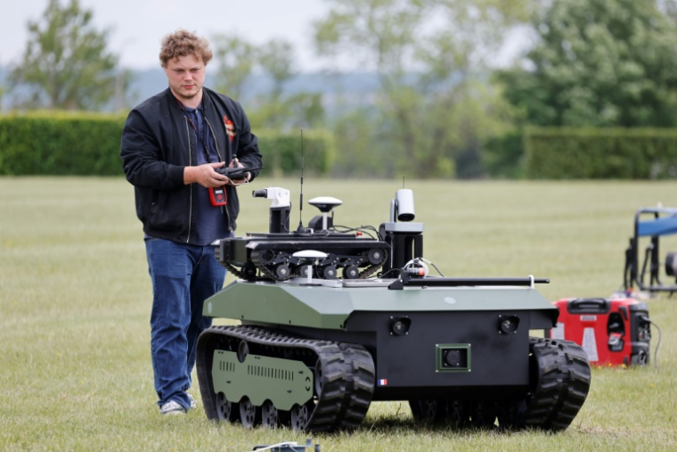 Un ingénieur effectue une démonstration d'un robot de combat lors du challenge CoHoMa, dans un camp d'entraînement militaire de la gendarmerie nationale, à Beynes, à l'ouest de Paris, le 6 mai 2025 ( AFP / Ludovic MARIN )